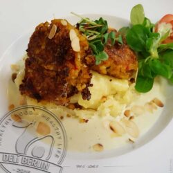 Bulgur-Bouletten auf Kartoffelpüree, begleitet von gerösteten Mandeln und einer feinen Lauchsauce.